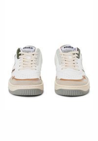 White sneaker featuring a mix of leather and suede, with beige accents, a green tab, and a gray rubber sole. Classic lace-up design.