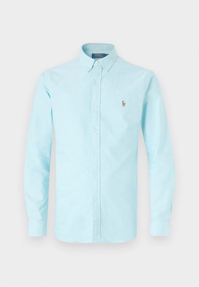 Light blue button-up shirt in cotton fabric, featuring a classic collar, long sleeves, and a small embroidered logo on the left chest.