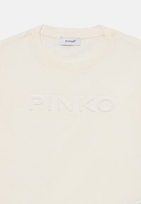 Kremkrāsas T-krekls ar apaļu kaklu un uzdurtu "PINKO" logotipu priekšpusē, izgatavots no mīkstas, gludas auduma. Vienkāršs un minimālistisks dizains.