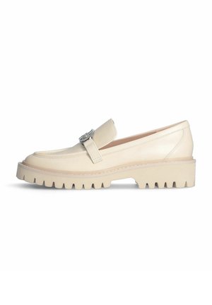 Mocassins en cuir couleur crème avec une large sangle et un accent métallique, dotés d'une semelle en caoutchouc épaisse avec des rainures profondes pour une meilleure adhérence.