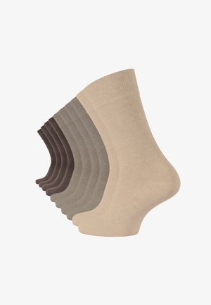 Cotton socks in a range of neutral tones, featuring ribbed tops and smooth textures, displayed in a staggered arrangement.