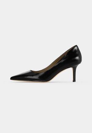 Chaussure à talon haut en cuir noir à bout pointu, avec un talon stiletto fin de hauteur moyenne et une finition lisse sur fond blanc.