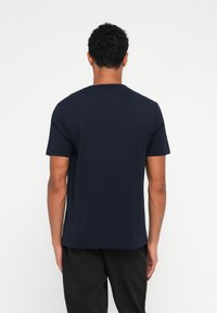 Navy crew-neck t-shirt in cotton jersey fabric. Short sleeves, straight cut, smooth texture, no visible patterns or embellishments.