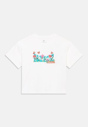 Tricou alb cu mâneci scurte Nike, cu textul "NIKE" albastru umplut cu flori roz, frunze verzi, fluturi portocalii și o pereche de sandale.