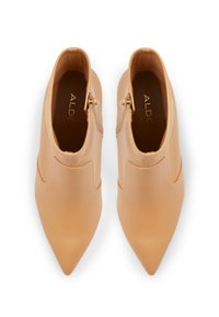 Stivali ankle con tacco alto color beige caratterizzati da una punta affilata, parte superiore in pelle liscia e cerniera laterale per una facile vestibilità. Design minimalista senza motivi.