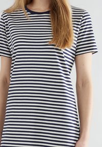 T-shirt a righe navy e bianche a maniche corte, con collo a girocollo, realizzato in un morbido tessuto di cotone e caratterizzato da righe orizzontali uniformemente distribuite.