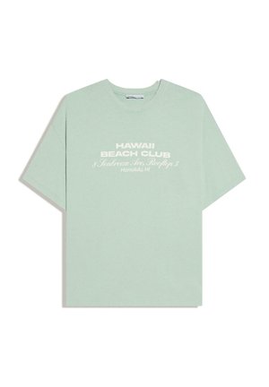 Tricou verde deschis cu gât rotund, având imprimat în alb, în centrul frontal, textul „HAWAII BEACH CLUB” și adresa.