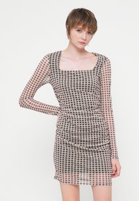 Rochie transparentă cu mâneci lungi, în carouri maro și alb, având un decolteu pătrat și detalii pliate pe laturi.