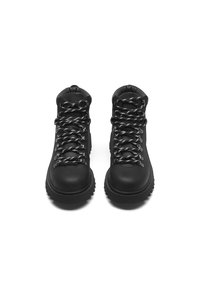 Black hiking boots with a matte finish, featuring metallic eyelets and textured laces. Thick rubber sole for traction and durability.