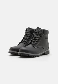 Botas de piel negra con cordones prominentes, cuello acolchado, suela resistente y costuras blancas en contraste; presenta el logo de FILA en el lado.