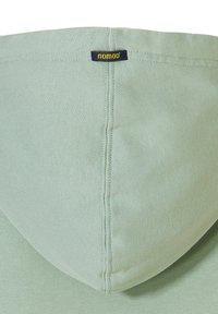 Lichtgroene hoodie met een soepele textuur. Heeft een capuchon en een geweven label met "nomad" in het geel op de achterkant van de nek.
