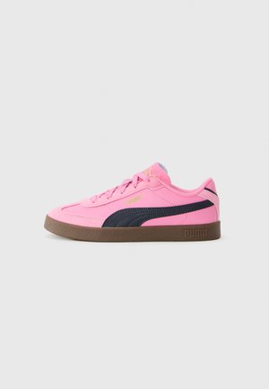 Baskets basses roses avec une bande noire Puma, semelle en gomme et logo doré Puma sur le côté et sur la langue, présentées en profil latéral.