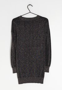 Pull noir à manches longues avec un effet pailleté métallique, doté d'un col et d'un ourlet côtelés, d'une texture lisse et d'une coupe ample. Suspendu à un crochet.