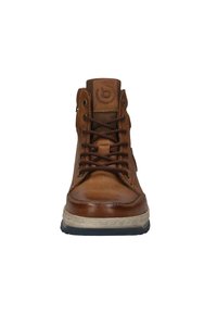 Braunes Leder-Hochschuh mit dunklen Schnürsenkeln, cremefarbener Gummisohle und einem runden Logo auf der Zunge. Verfügt über eine glatte Oberfläche und gestickte Akzente.