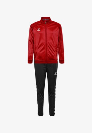 Rød træningsjakke og sorte bukser lavet af glat materiale. Jakken har høj krave og sidelommer; bukserne har chevron-accenter og logoer.