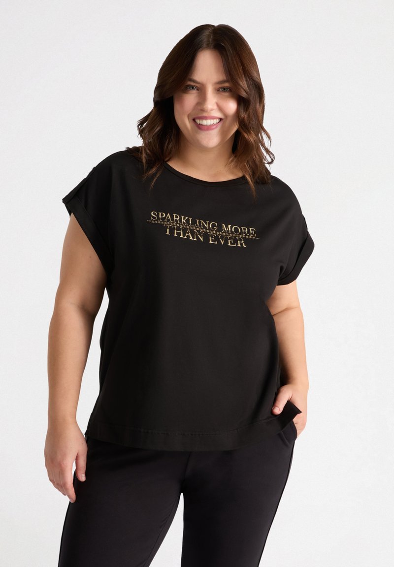 Schwarzes Baumwoll-T-Shirt mit kurzen, aufgerollten Ärmeln und einem runden Ausschnitt. Vorn bedruckt mit goldenem Text "SPARKLING MORE THAN EVER".