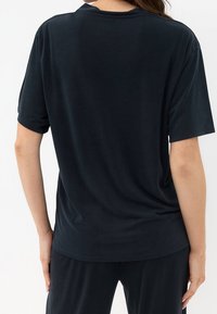 T-shirt nero a maniche corte con vestibilità comoda, realizzato in tessuto morbido. Presenta un collo rotondo e una texture liscia, visibile dal retro.