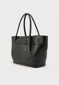 Sac fourre-tout en cuir noir avec deux longues poignées, texture douce et détail de couture le long du centre, présentant un design structuré mais flexible.