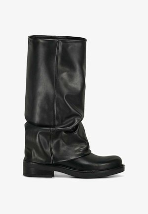 Stivale alto in pelle nera con gambale morbido, tacco basso e punta arrotondata, mostrato di profilo su sfondo bianco.