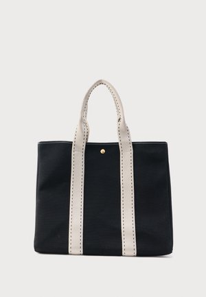 Černá taška přes rameno se dvěma širokými béžovými úchyty prošitými černou nití, s malým zlatým knoflíkem poblíž horního středu.