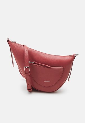 Red leather handbag with a rounded shape, silver-tone hardware, and a front zip pocket. Adjustable strap for crossbody wear.