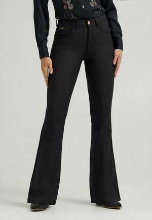 Vaqueros acampanados negros de cintura alta, hechos de denim. Presentan bolsillos frontales y traseros, un emblema dorado y una textura suave.