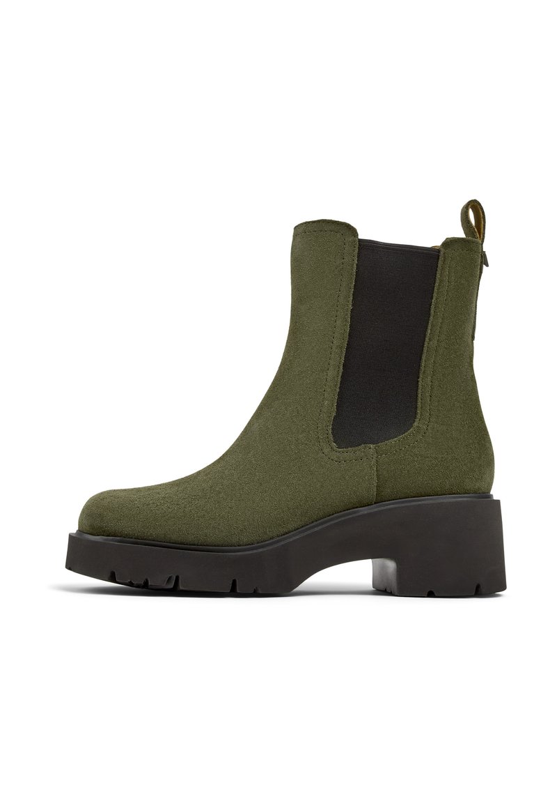 Stivaletto verde in suede con una robusta suola nera a piattaforma, pannelli laterali elasticizzati e un tassello posteriore per facilitare l'indosso.