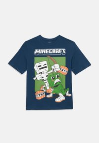 Tamsiai mėlynas Minecraft marškinėliai su animaciniu skeletu, laikantiu lanką ir strėlę, bei žaliu creeperiu, laikantiu TNT blokelius prieš žalią fono.