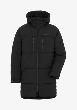 Schwarze Steppjacke mit Kapuze, Reißverschluss vorne, zwei Brusttaschen und gestepptem Design, kombiniert mit olivfarbener Cargo-Hose und schwarzen Turnschuhen.