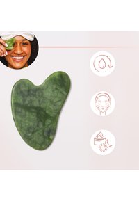 Grünes Jade-Gua-Sha-Werkzeug in Herzform, mit glatter Textur und sichtbaren Marmorierungen, entworfen für Gesichts-Massagen und Hautpflege.
