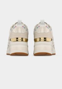 Paire de baskets compensées beiges avec broderie florale, accents métalliques dorés et logo ALDO sur la languette du talon, vue de dos.