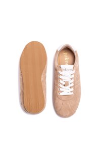 Zapatillas de ante beige con cordones blancos, puntera redondeada y suela de goma marrón con un patrón de espiga. Logo en la lengüeta.