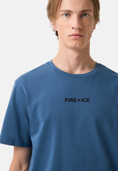 Modré bavlněné tričko s krátkým rukávem a kulatým výstřihem. Na hrudi je černé logo "FIRE + ICE". Jednoduchý design, hladká textura.
