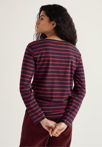 Hosszú ujjú ing, tengerészkék és piros vízszintes csíkokkal, pamut anyagból, kerek nyakkivágással és laza fit-tel.