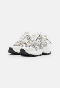 Vita och grå sneakers med en mesh-överkonstruktion, texturerade detaljer, tjock svart sula och distinkta flerfärgade snören.