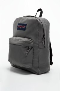 Sac à dos gris Jansport avec un compartiment principal et une poche avant, fabriqué en tissu durable, doté de bretelles noires et d'un patch logo.