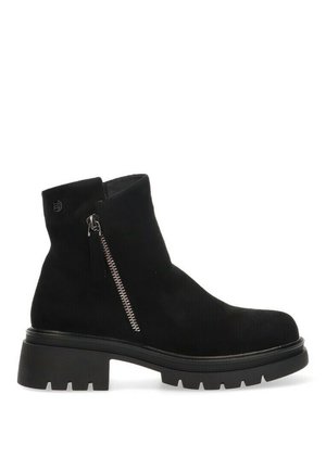 Bota de tobillo de ante negra con cremallera lateral, suela de goma gruesa y un diseño minimalista con textura suave.