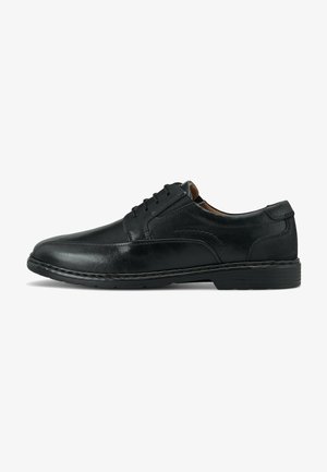 Scarpa da uomo in pelle nera, con punta rotonda, sei fori per i lacci, dettagli cuciti e suola in gomma nera. Texture liscia con una finitura lucida.