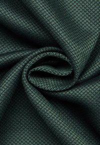 Tessuto verde scuro con una trama a spina di pesce, caratterizzato da fili strettamente intrecciati che creano una superficie liscia e leggermente lucida.