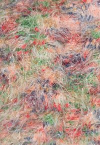 Tissu en fausse fourrure multicolore avec des fibres longues et lâches en vert, rouge, orange et bleu, présentant une apparence brillante et texturée.