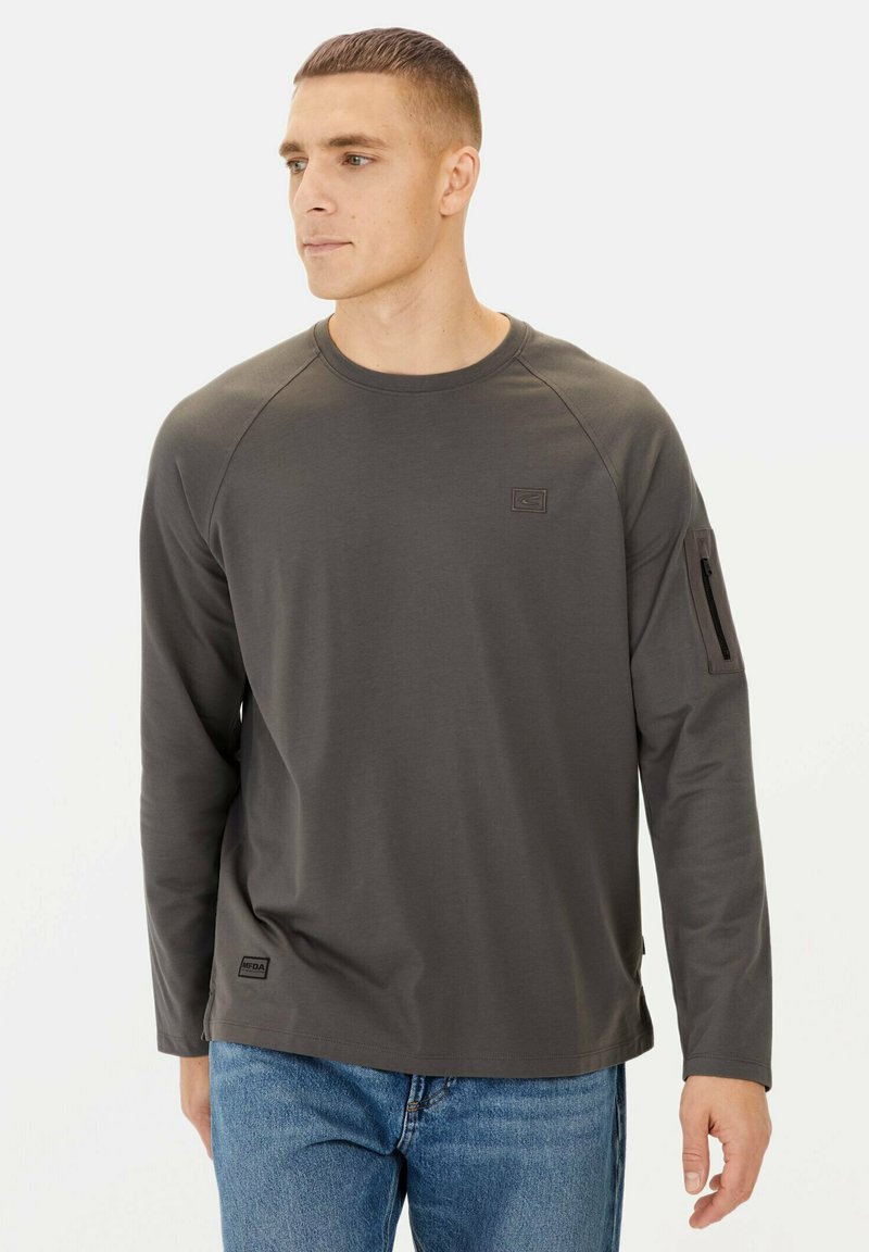Graues Langarmshirt mit Rundhalsausschnitt, Raglanärmeln, Logo-Patch auf der Brust und Reißverschlusstasche am linken Arm. Glatte Textur, lässiges Design.