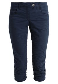 Marinblå cropped byxor med knapp- och dragkedjespänning, fram- och bakfickor samt rynkade tygeralong benen.