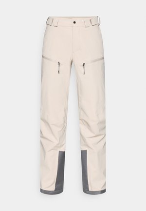 Light beige outdoor pants with a smooth texture, two zippered pockets at the thighs, and gray accents at the cuffs. Adjustable waistband.