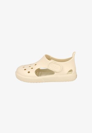 Zapato de agua infantil de color crema con orificios de ventilación, talón ajustable con etiqueta "igor" y suela texturizada para mejor agarre.