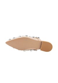 Zapato beige de punta afilada con una suela texturizada, adornado con acentos esféricos plateados a lo largo del costado. Material superior suave.