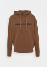 Sudadera con capucha marrón fabricada en tejido suave, con un bolsillo tipo canguro en la parte delantera y texto impreso en negro en el pecho. Puños y dobladillo acanalados.