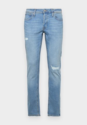 Vaaleansiniset farkut, joissa on suora lahje, kuluneet polvikohdat ja klassinen viisi-taskuinen muotoilu.