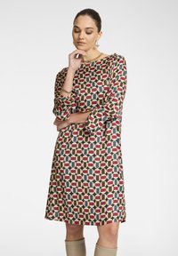 Langärmliges Kleid mit geometrischem Muster in Rot, Grün und Beigefarben. Hergestellt aus glattem Stoff mit lockerer Passform und knielanger Saum.