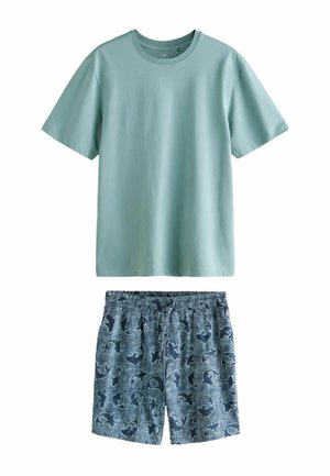 Lyseblå T-shirt med korte ærmer kombineret med blå shorts med elastisk talje med mørkt hajmønster.