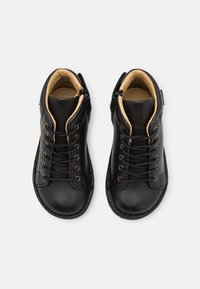 Sorte lær ankle boots med rund tå, beige indvendig foring, snørelukning fortil og dekorativ syning, der har en struktureret ydersål.